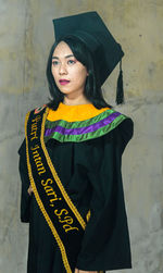 Portrait of woman standing against wall