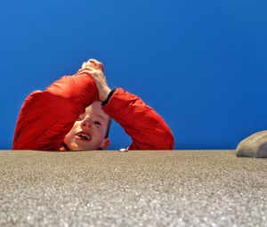 Low angle view of boy against blue sky
