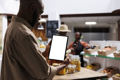 Midsection of man using mobile phone