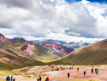 Group of people on mountain range against sky