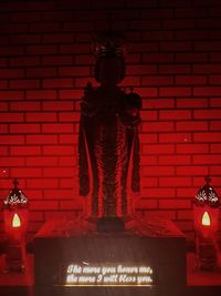 Close-up of illuminated statue against brick wall