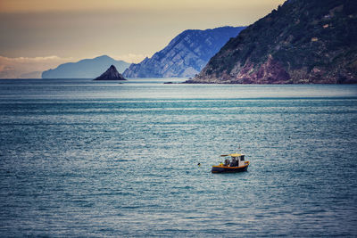 Scenic view of sea against mountain range with italian fisherman insidie his boat. 