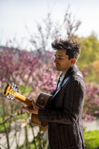 Side view of young man holding violin