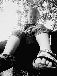 Low angle view of girl sitting outdoors