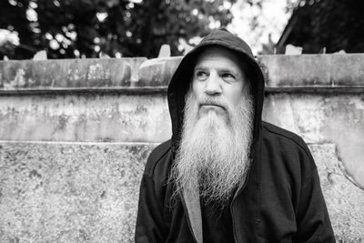 Portrait of man looking away against wall