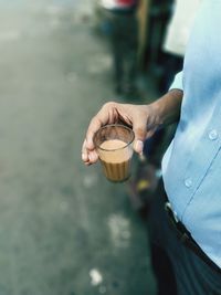 Midsection of man having tea outdoors