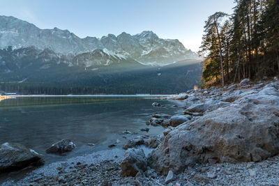 Scenic view of lake by mountains against sky