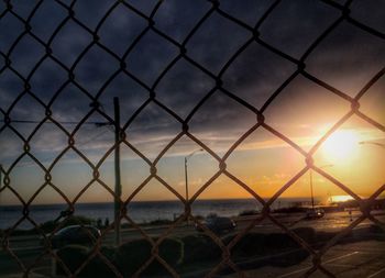 Scenic view of sea seen through chainlink fence