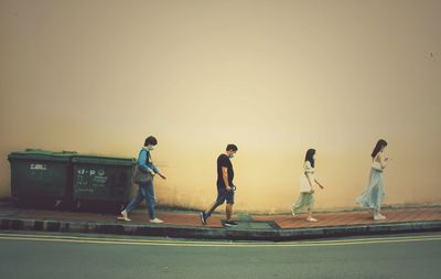 People walking on road against clear sky