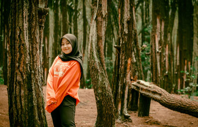 Portrait of a smiling young woman in forest