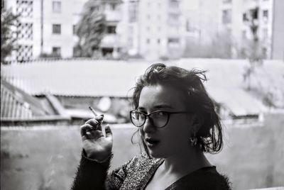 Portrait of young woman smoking cigarette