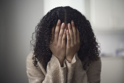 Young woman covering face with hands