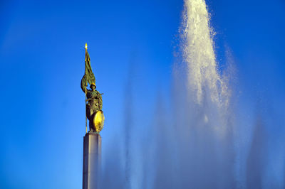 Low angle view of statue against blue sky