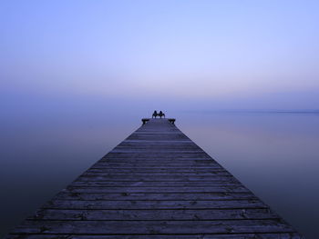 Pier on sea at sunset