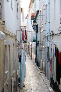 Clothes drying on alley amidst buildings in city