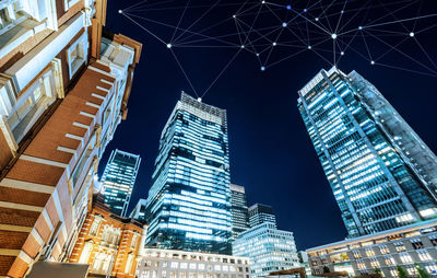 Low angle view of illuminated buildings against sky at night