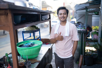 Portrait of young man standing in market