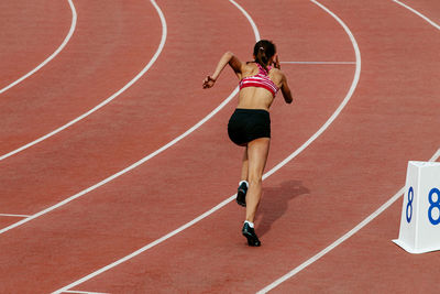 Girl runner athlete start of 400 meters race track and field competition