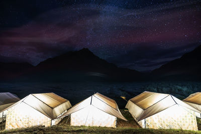 Illuminated tents against star field at night