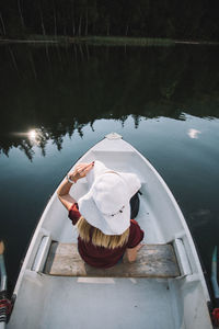 High angle view of woman sitting in boat on lake