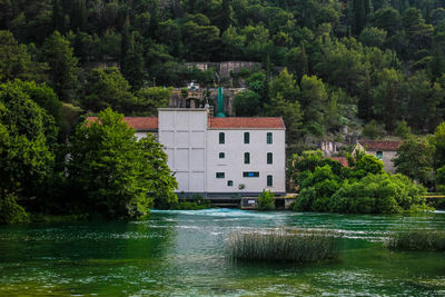 House by lake and trees in forest