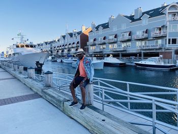 Man on boat in canal against sky in city