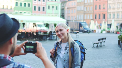 Portrait of woman photographing in city