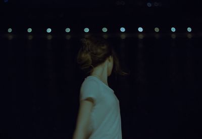 Girl standing outdoors at night