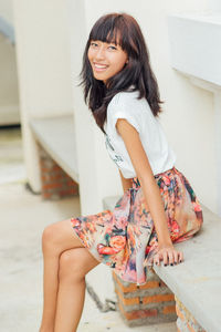 Portrait of a smiling young woman standing at home