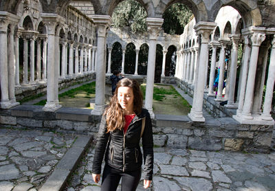 Portrait of smiling woman standing against building