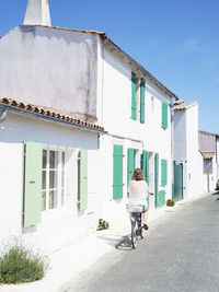 Rear view of woman riding bicycle on building