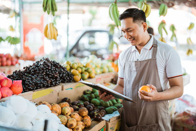 Portrait of man holding fruits at market
