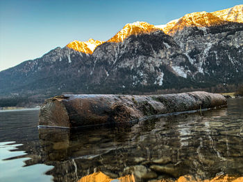 Rocks in lake against mountain range