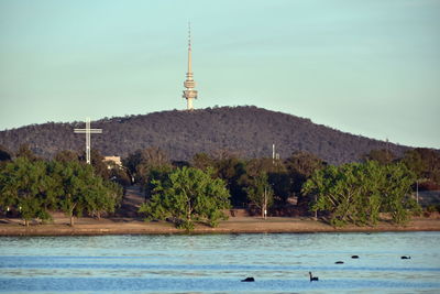 Scenic view of river by trees against sky