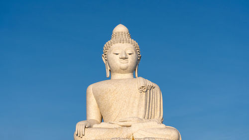 Low angle view of statue against blue sky