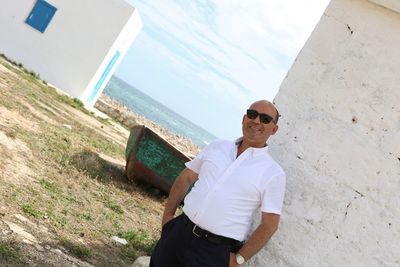 Portrait of mature man wearing sunglasses while standing at beach