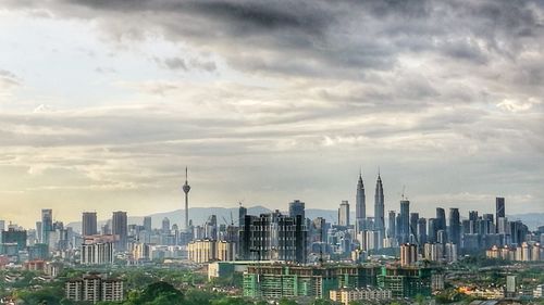 View of cityscape against cloudy sky