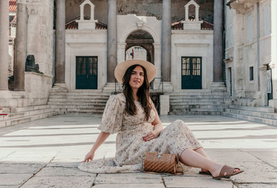 Beautiful young woman sitting on peristyle of diocletian's palace in split, croatia