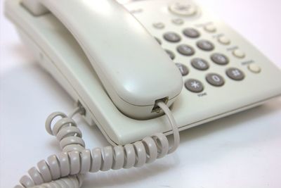 Close-up of white telephone on table