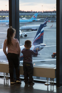 Rear view of two people standing in glass window