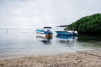 Boat moored in sea against sky