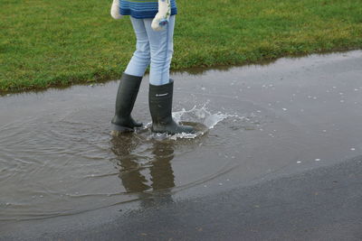 Low section of man standing in puddle