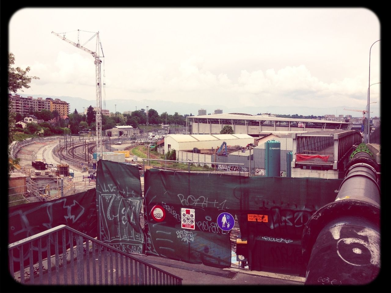 transfer print, building exterior, architecture, built structure, auto post production filter, sky, city, communication, transportation, outdoors, cloud - sky, connection, construction site, day, development, text, cloud, no people, city life, cityscape