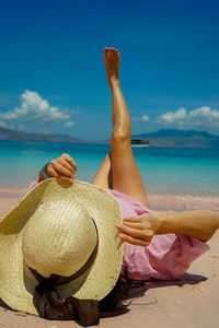 Rear view of woman sitting at beach