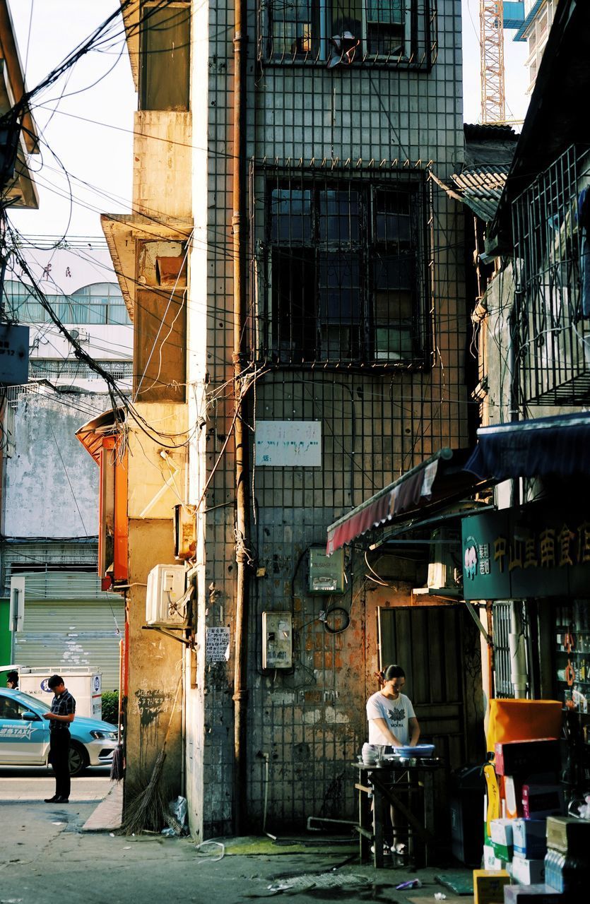 PEOPLE ON STREET AGAINST BUILDINGS