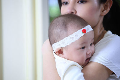 Close-up of mother carrying daughter at home