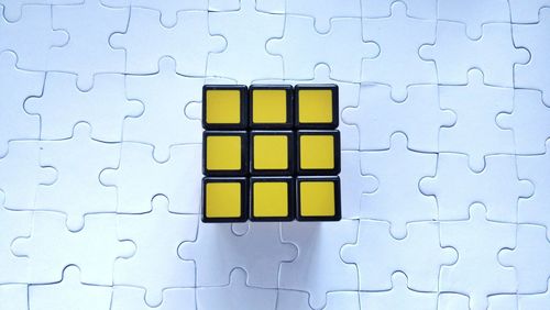 Directly above shot of puzzle cube on jigsaw pieces