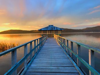 Pier over sea against sky during sunset