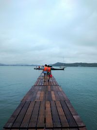 View of pier on calm sea against sky