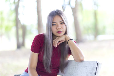 Portrait of beautiful young woman sitting outdoors